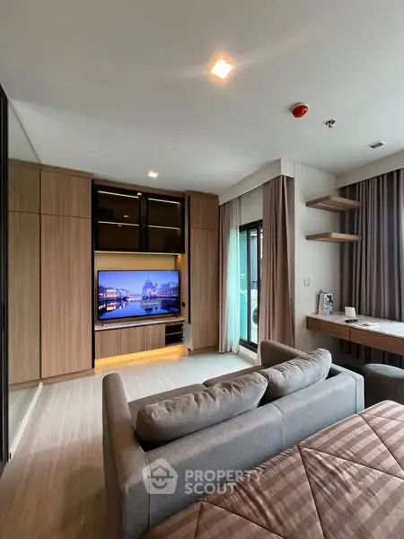 Modern living room with cozy sofa and entertainment center, featuring sleek design and natural light.