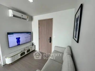 Modern living room with sleek design, featuring a wall-mounted TV and stylish air conditioning unit.