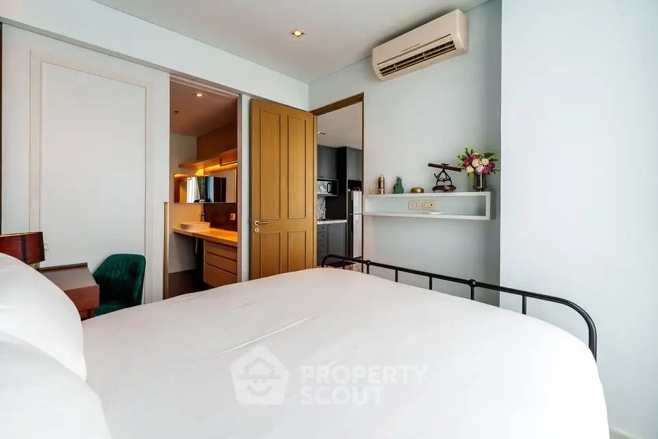 Modern bedroom with ensuite bathroom and air conditioning in stylish apartment.