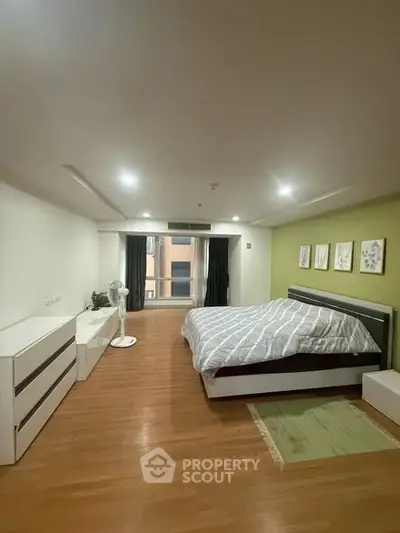 Spacious modern bedroom with stylish decor and ample natural light.