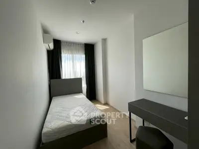 Modern minimalist bedroom with natural light and sleek furnishings.