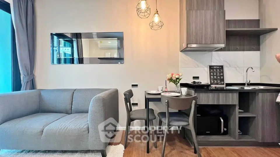 Modern living room with stylish kitchen and cozy dining area in open layout apartment.