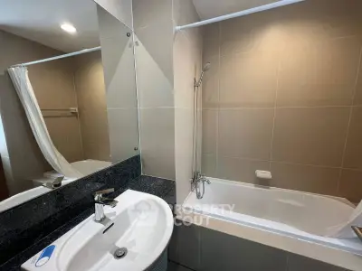 Modern bathroom with sleek design and bathtub in contemporary apartment.