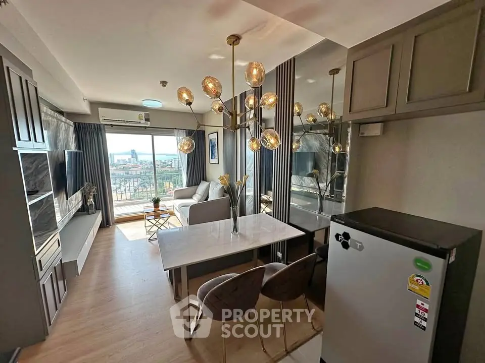 Modern living room with stylish chandelier and city view, featuring open layout and sleek furniture.