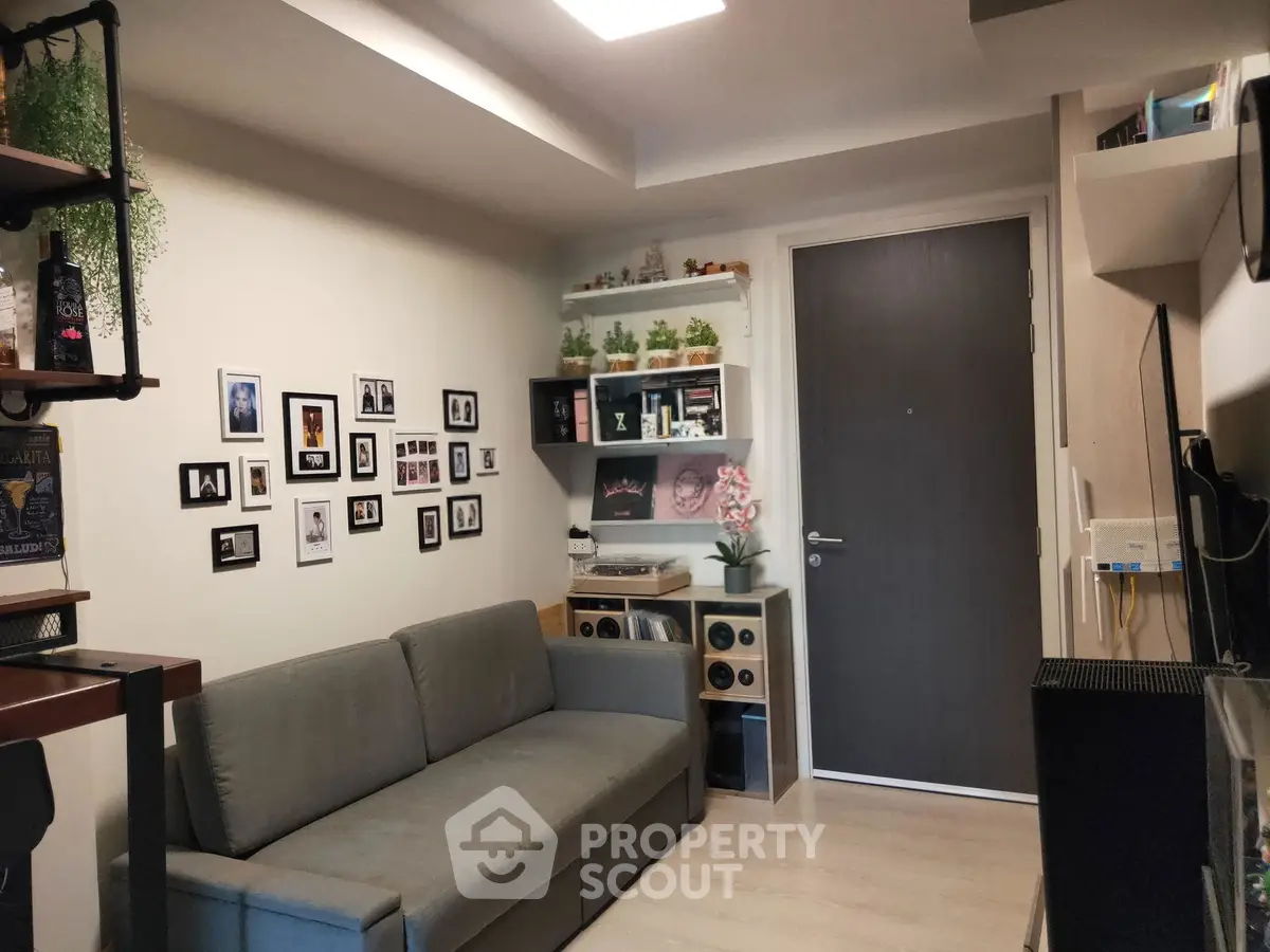 Cozy living room with modern decor and wall art, featuring a comfortable sofa and stylish shelving.