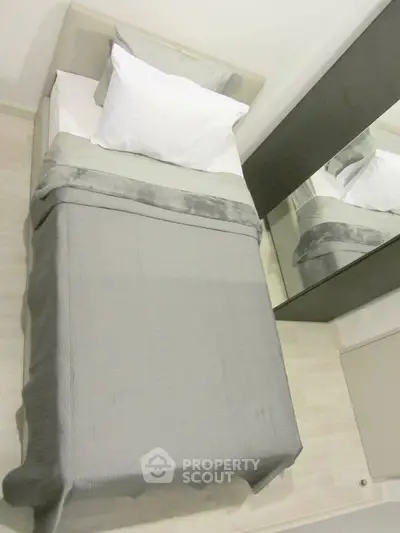 Cozy minimalist bedroom with single bed and mirrored wardrobe