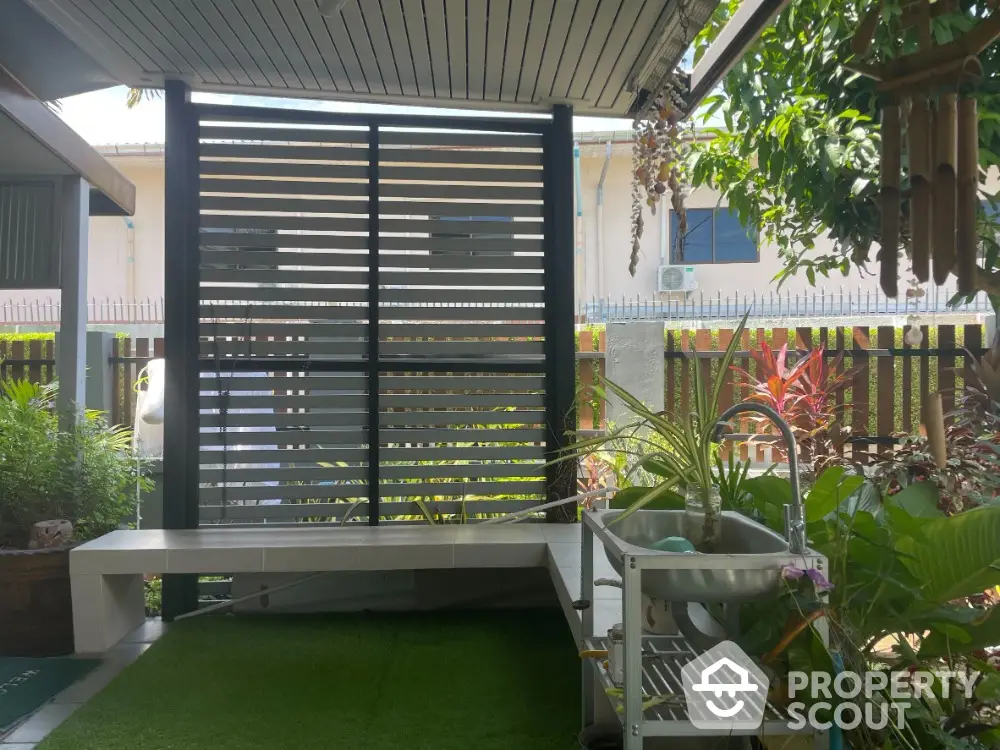 Charming garden area with modern bench and lush greenery, perfect for relaxation and outdoor enjoyment.