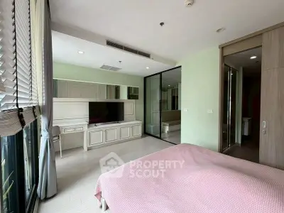 Spacious bedroom with modern decor and large windows for natural light