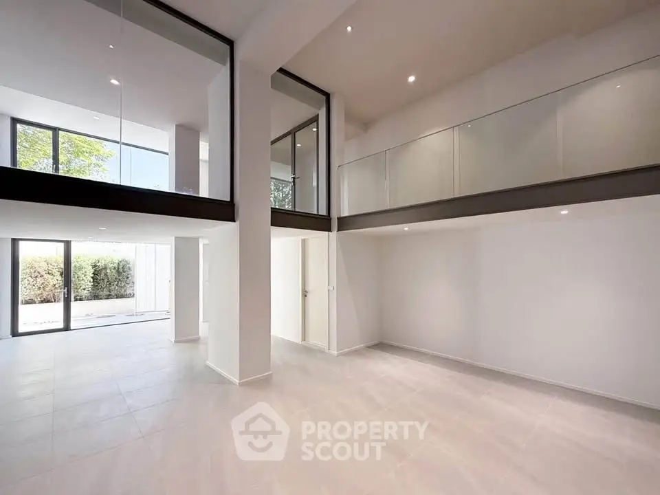 Spacious modern living room with high ceilings and large windows offering natural light.