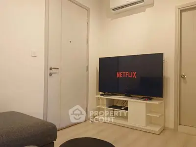 Cozy living room with modern TV setup and air conditioning.