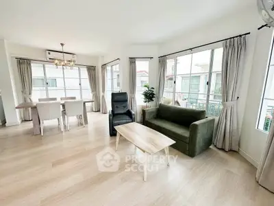 Spacious living room with modern furniture and large windows offering natural light