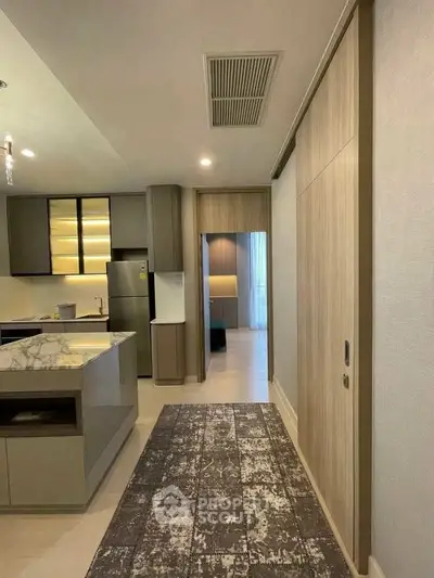 Modern kitchen with marble island and sleek cabinetry in a stylish apartment.
