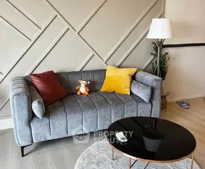 Stylish living room with modern gray sofa and chic decor accents.