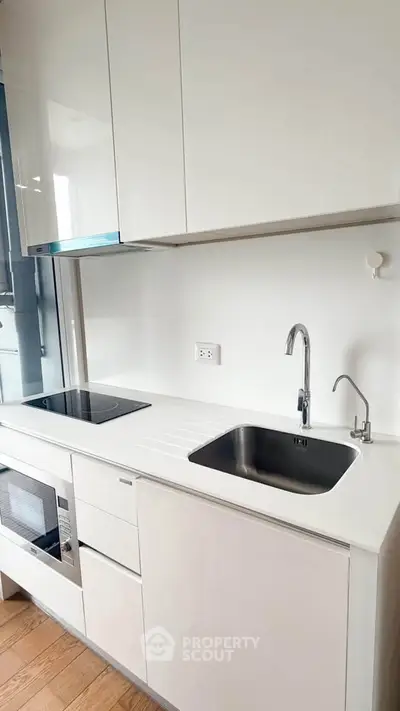 Modern kitchen with sleek white cabinetry and built-in appliances
