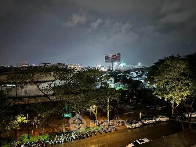 Stunning night cityscape view with illuminated skyline and parked vehicles, perfect for urban living enthusiasts.