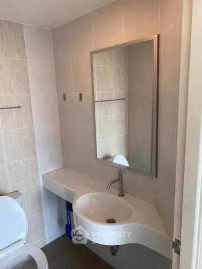 Modern bathroom with sleek sink and mirror in a stylish real estate property.
