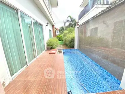 Charming private pool area with wooden deck and lush greenery, perfect for relaxation and entertainment.