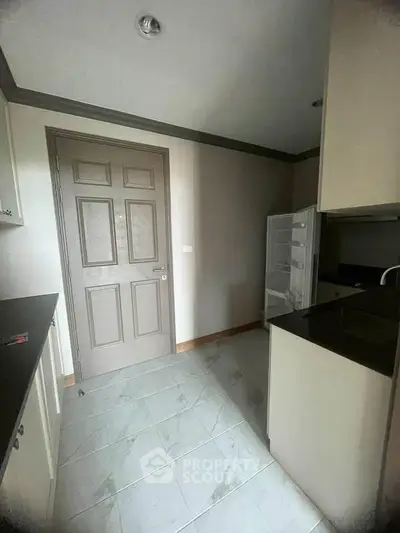 Modern kitchen with sleek cabinetry and open fridge in a compact layout