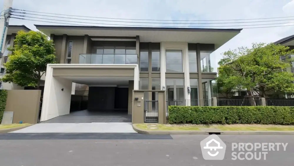 Modern luxury house exterior with spacious driveway and lush greenery