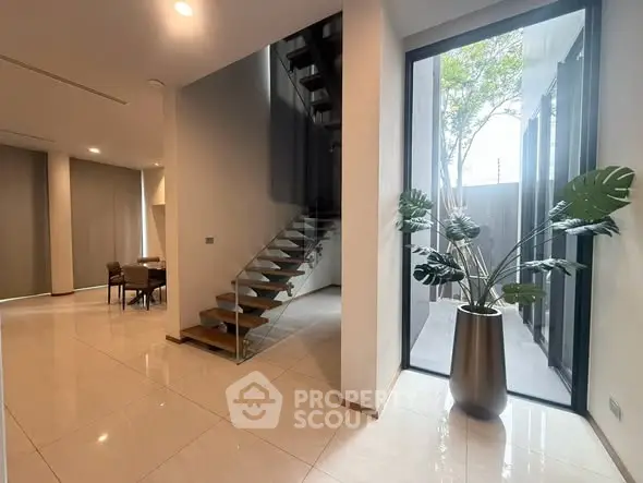 Modern interior with elegant staircase and large window view