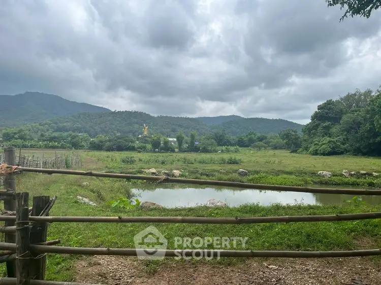 Scenic rural landscape with lush greenery and mountains under cloudy sky