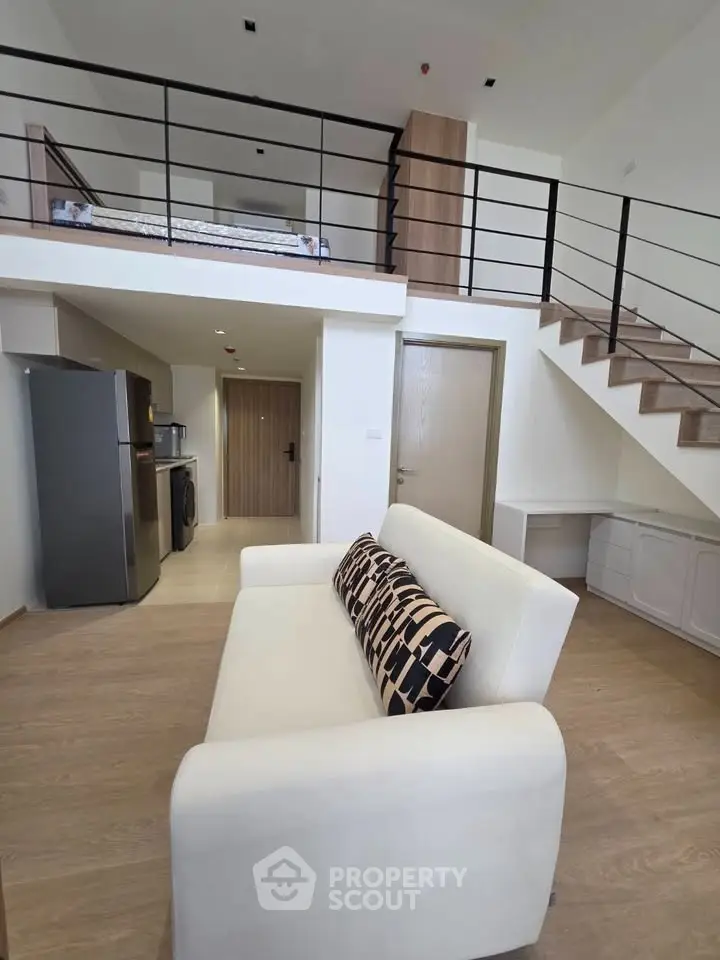 Modern loft apartment with stylish open layout and mezzanine bedroom, featuring sleek kitchen appliances and cozy living area.