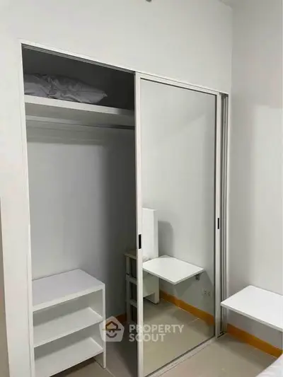 Modern bedroom with sliding mirrored closet and built-in shelves