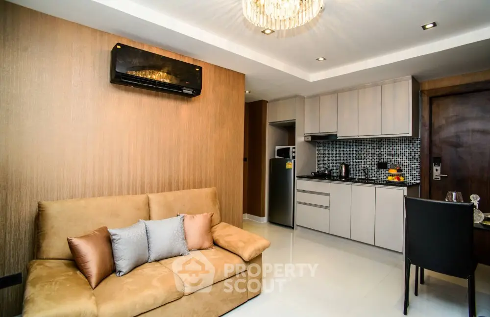 Modern living room with open kitchen, stylish decor, and cozy seating in a contemporary apartment.
