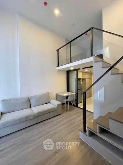 Modern loft apartment with sleek staircase and cozy living area, perfect for urban living.