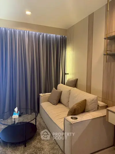 Cozy living room with modern sofa and elegant curtains, perfect for relaxation.