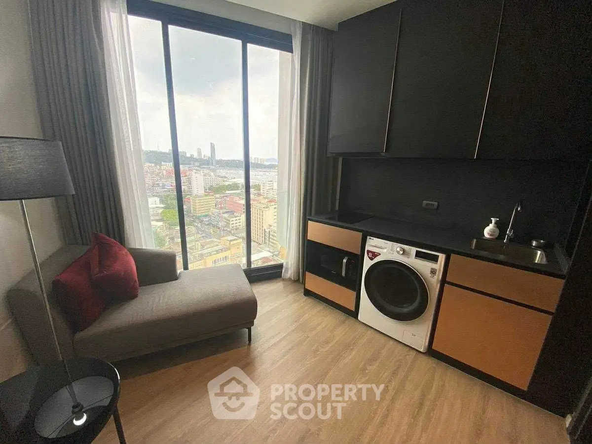 Modern apartment with city view, featuring a cozy seating area and in-unit laundry for urban living.