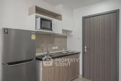 Modern kitchen with sleek appliances and stylish cabinetry in a compact layout.