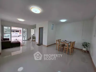 Spacious living room with dining area and natural light, ideal for family gatherings.