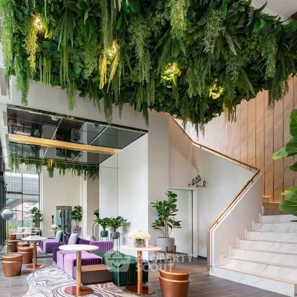 Luxurious modern lobby with lush greenery and elegant staircase