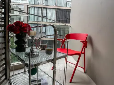 Chic urban balcony with modern red chair and stylish decor overlooking cityscape.