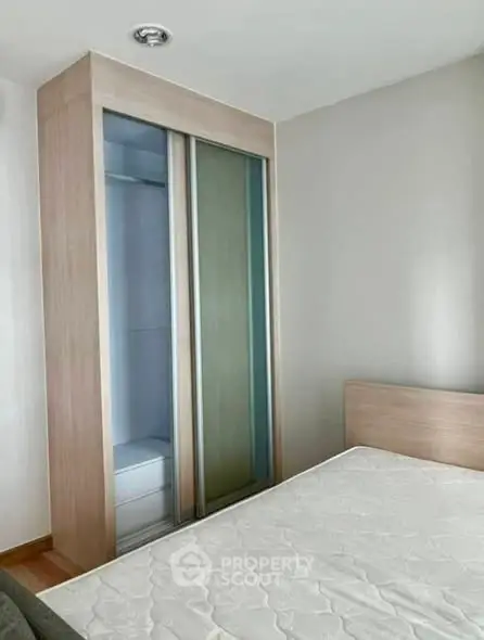 Modern bedroom with sleek sliding wardrobe and comfortable bed