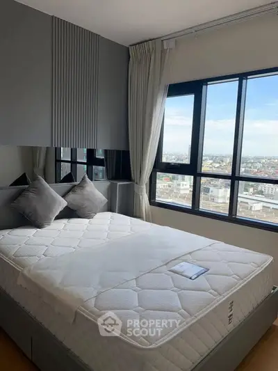 Modern bedroom with large window offering stunning city view, featuring a comfortable bed and elegant decor.