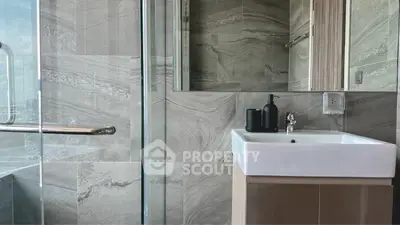 Modern bathroom with sleek sink and glass shower enclosure