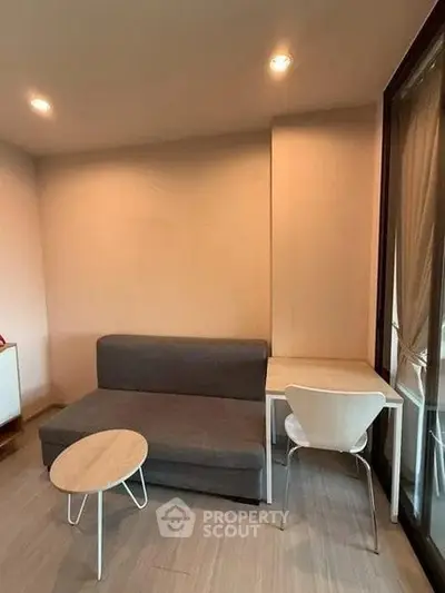 Cozy living room with modern sofa and stylish chair, perfect for relaxation and work-from-home setup.