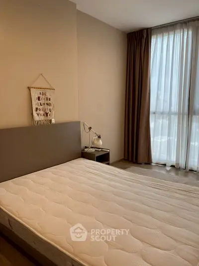 Cozy bedroom with natural light and modern decor, perfect for relaxation.