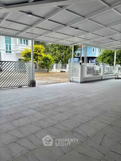 Spacious covered patio with tiled flooring and modern railing, perfect for outdoor relaxation.