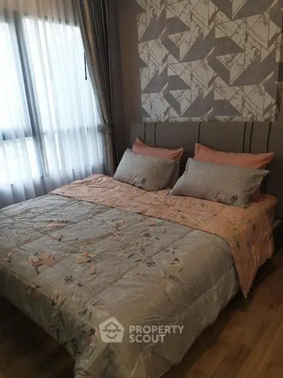 Cozy bedroom with stylish decor and large window for natural light