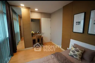 Modern bedroom with stylish decor and wooden flooring, featuring a cozy bed and a dressing table with mirror.