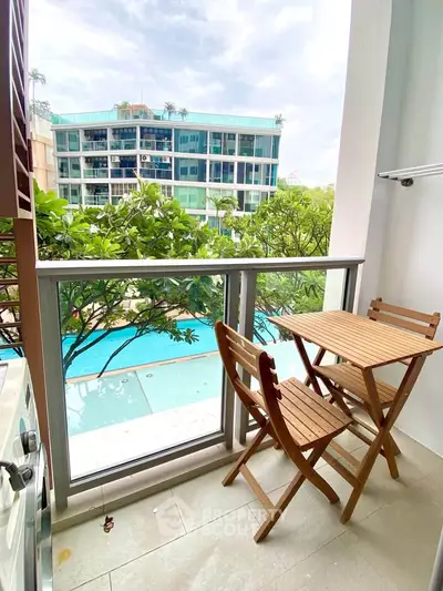 Charming balcony with pool view, perfect for relaxing and enjoying outdoor dining in a modern residential complex.