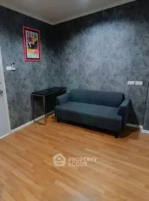 Cozy living room with modern gray sofa and stylish wall decor, perfect for relaxation.
