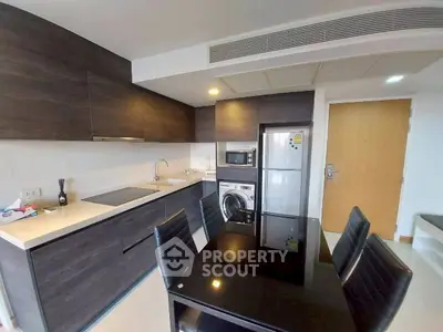 Modern kitchen with sleek cabinetry and dining area in contemporary apartment