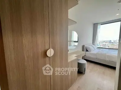 Modern bedroom with wooden wardrobe and city view from large window