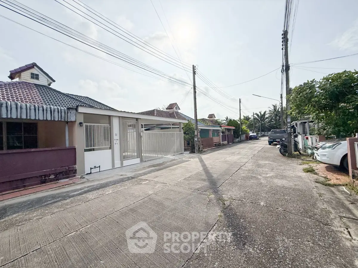 Charming residential street with single-story homes and lush greenery.