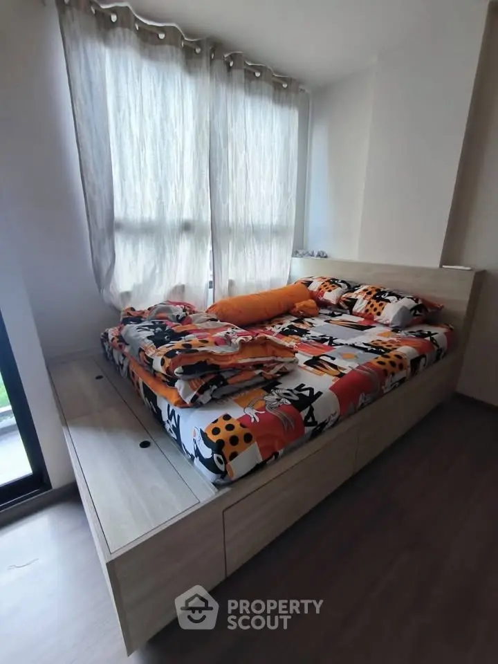 Cozy bedroom with stylish bed and natural light from large windows.