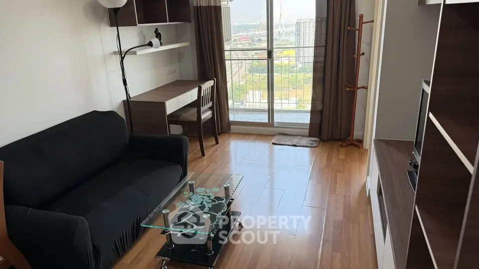 Modern living room with wooden flooring, glass coffee table, and balcony view in a stylish apartment.